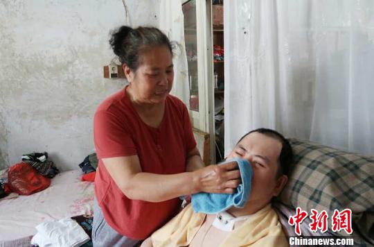 每次喂完食物后，梁青蘭都要仔細(xì)地幫兒子清理干凈。　尚明俠 攝