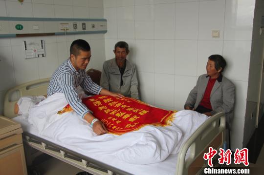 被救的李忠起、張總鳳夫婦看望受傷后的李運(yùn)飛?！⊥粲?攝