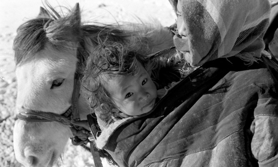 1990年3月，西藏當(dāng)雄縣納木湖鄉(xiāng)三村女牧民斯卓不畏嚴(yán)寒，懷抱幼子，準(zhǔn)備到遠(yuǎn)處放牧。新華社記者覺(jué)果攝